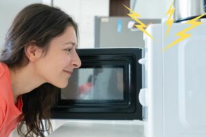 how many amps does a microwave use - woman looking into microwave