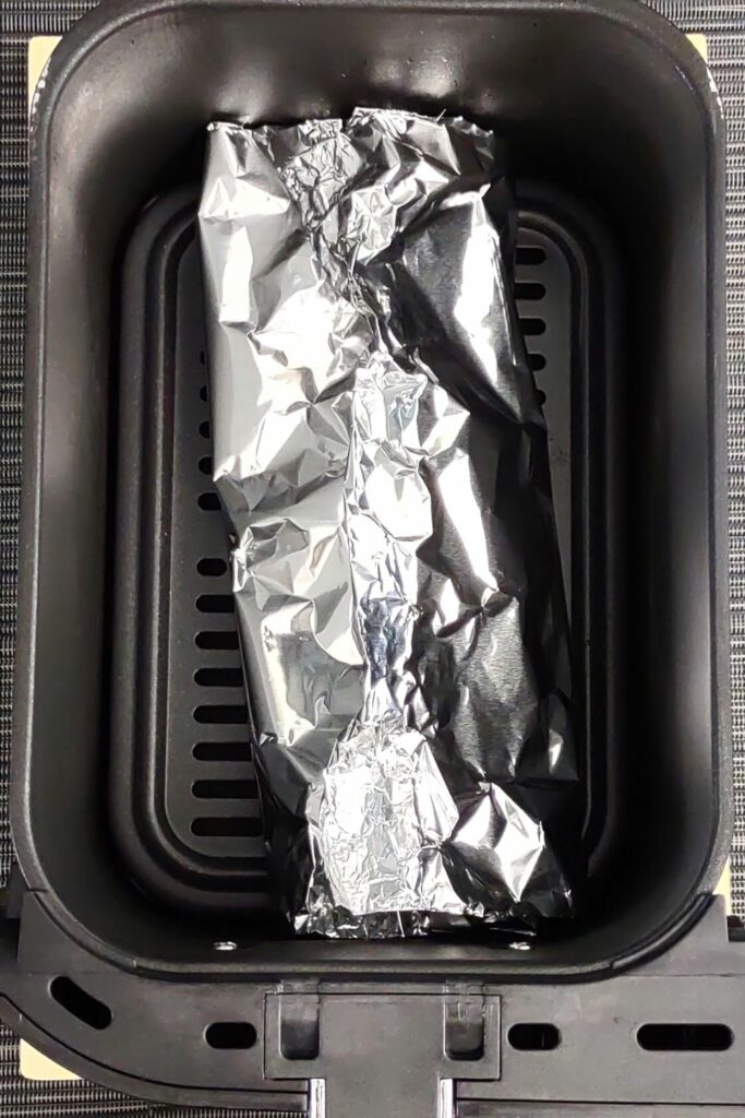 place aluminum foil potato skins packet into air fryer basket