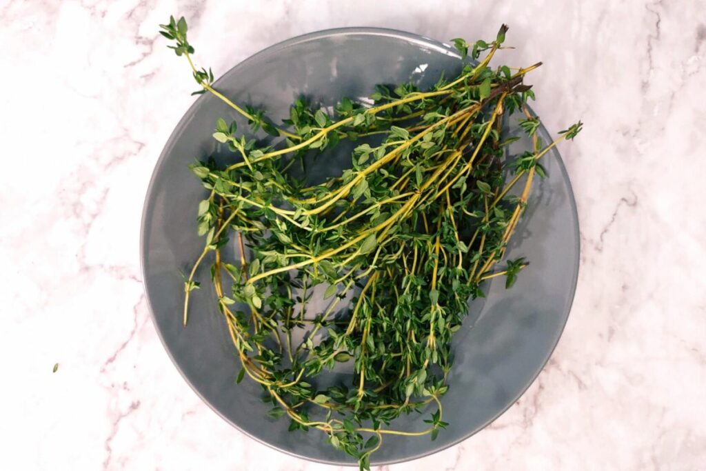 sprigs of fresh thyme cleaned on a plate