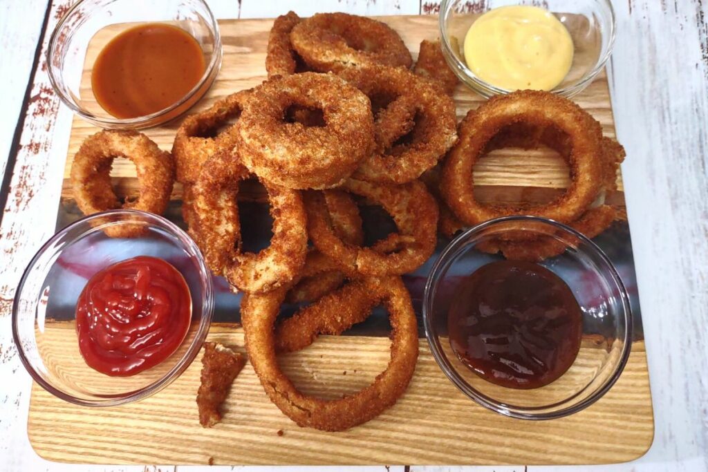 golden brown air fryer onion rings with sauce sides