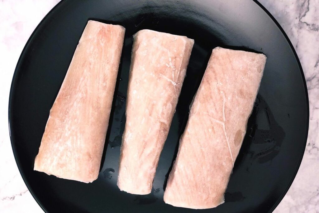 lay and spread out frozen fish fillets on plate