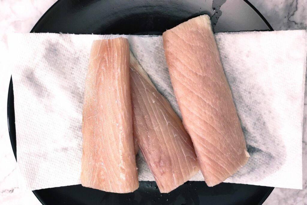 laying defrosted fish fillets on paper towel