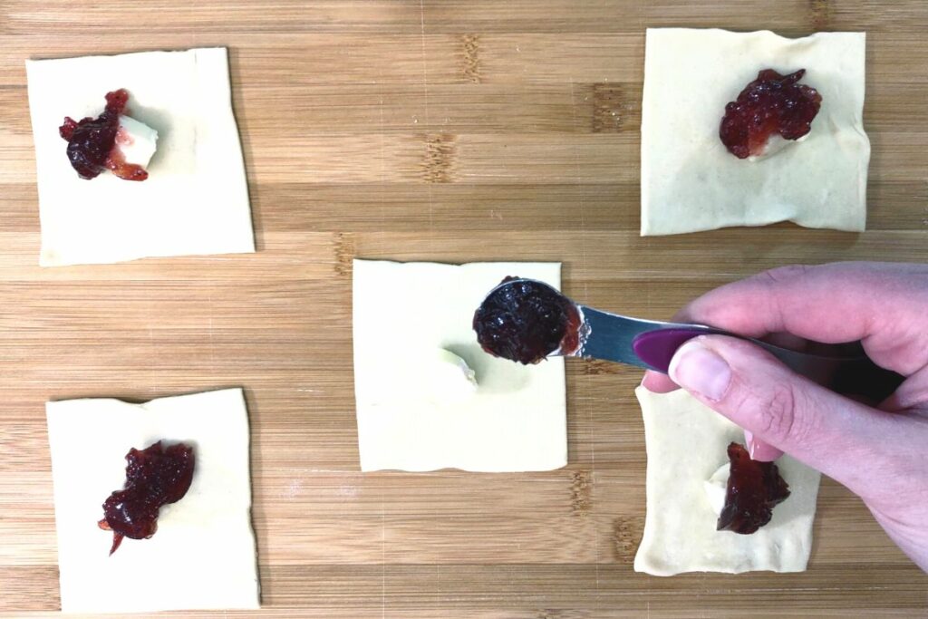 place a cube of brie and cranberry preserves in the center of puff pastry square