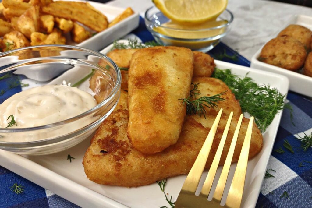 air fried beer battered fish on a plate with tartar sauce and a fork