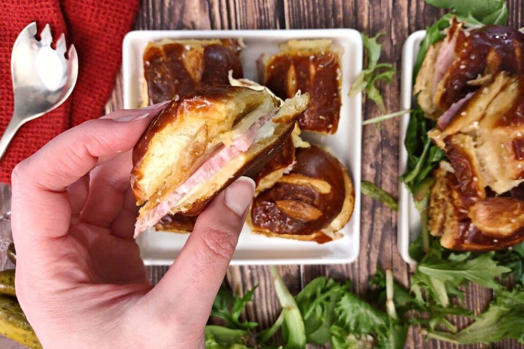 holding a ham and cheese pretzel slider from the air fryer
