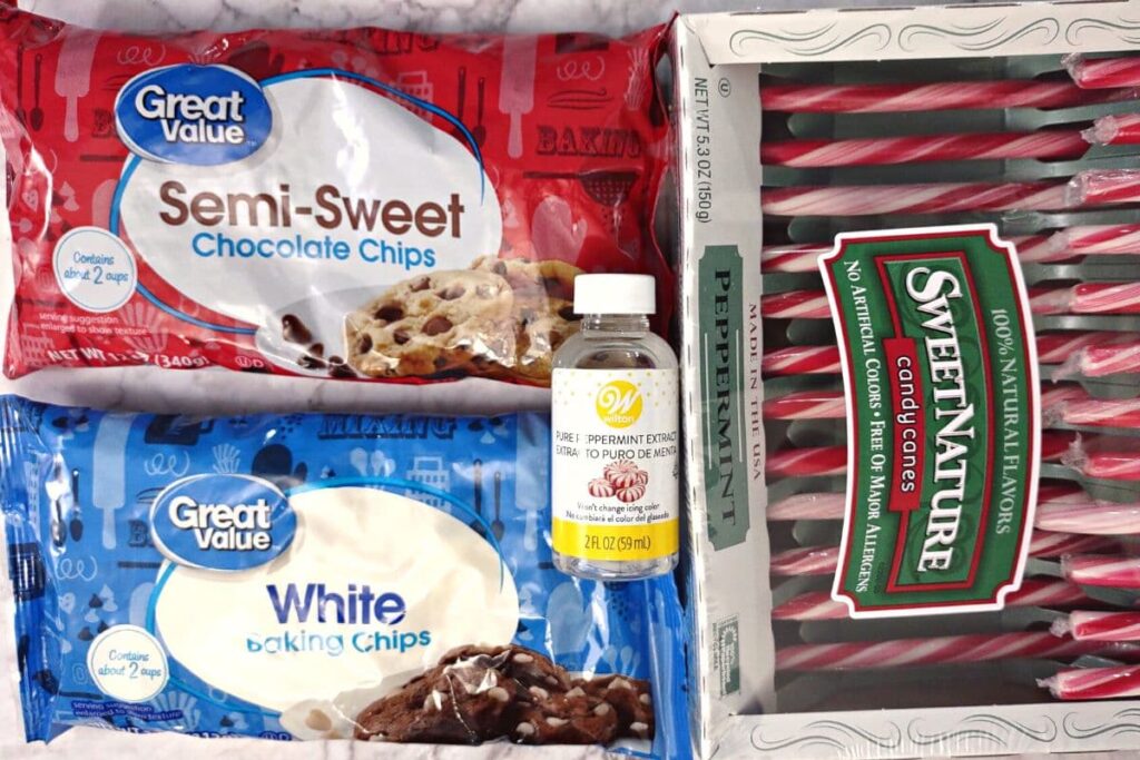 ingredients to make peppermint bark including white and dark chocolate chips, peppermint extract, and candy canes