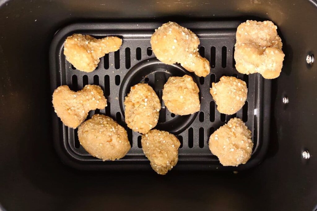 frozen cauliflower wings in an air fryer basket