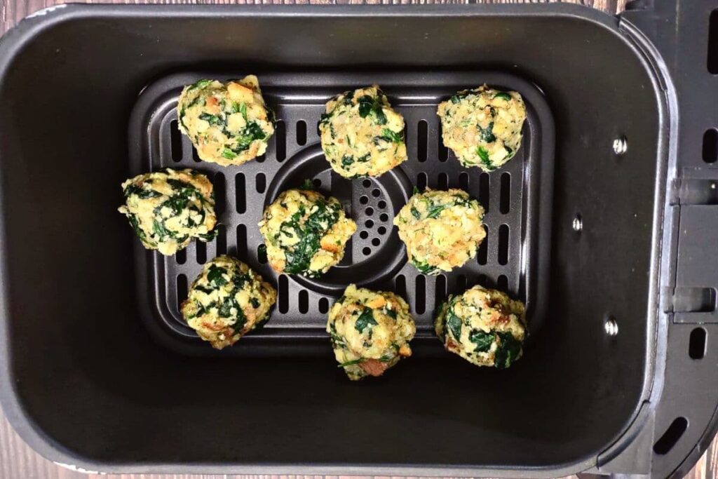 place uncooked spinach balls in air fryer basket
