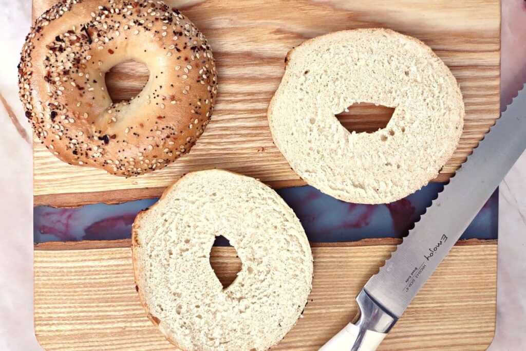 overhead view of a bagel cut in half with a knife