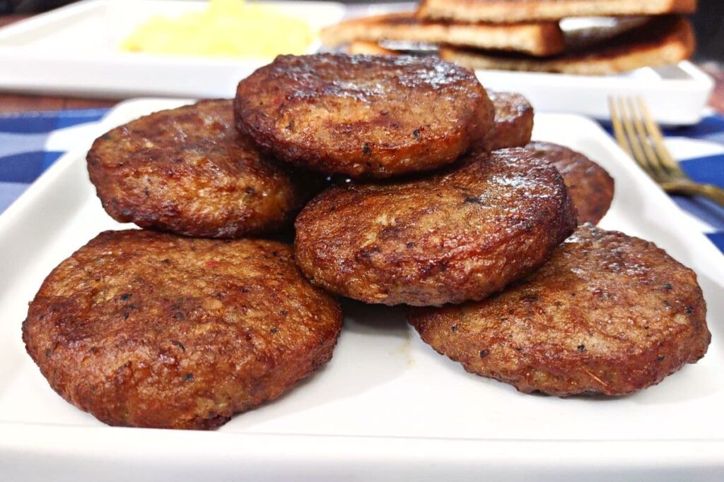 close up of frozen jimmy dean sausage patties cooked in the air fryer and stacked on a plate