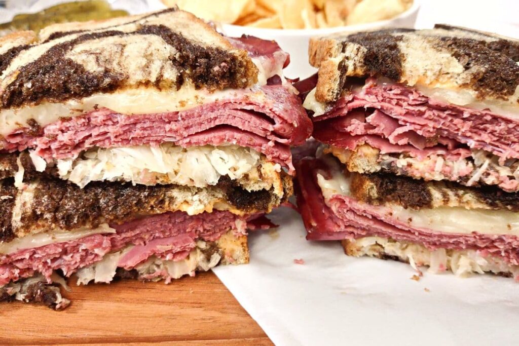 closeup of reuben sandwich cut in half stacked on top of each other
