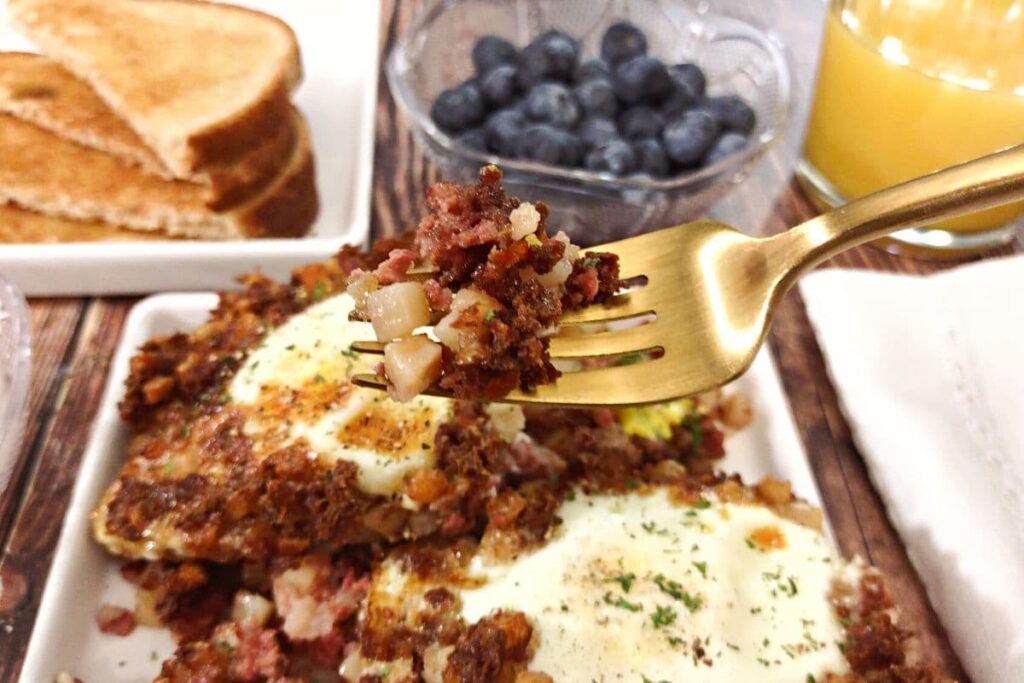 corned beef hash with eggs on a fork