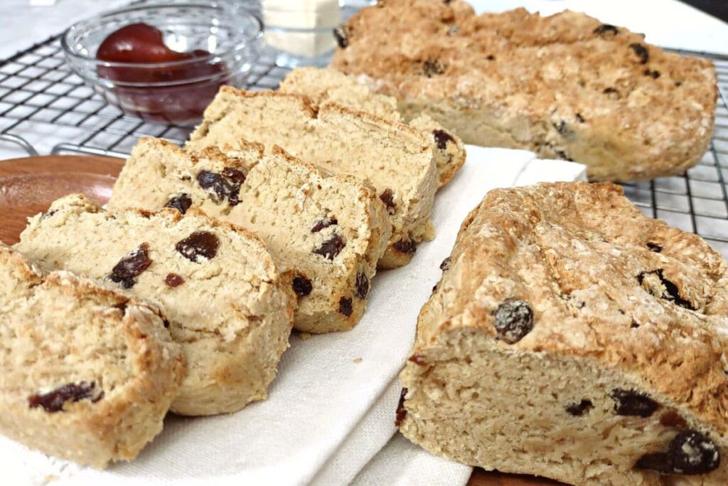 slices of irish soda bread with raisins next to the loaf half