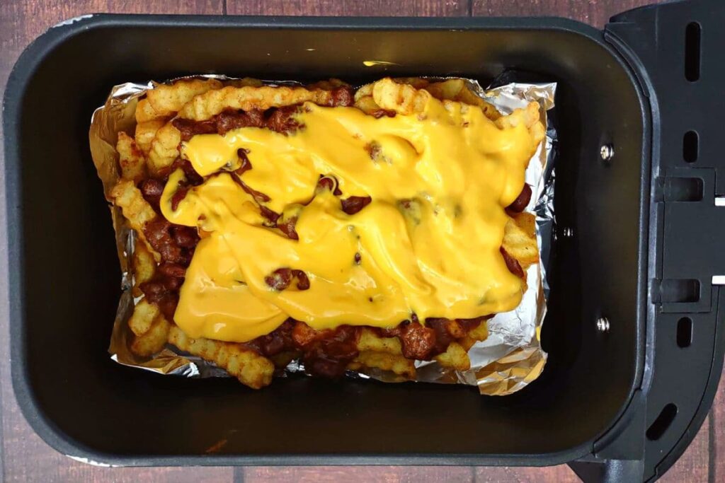 add cheese on top of the chili fries and warm the cheese