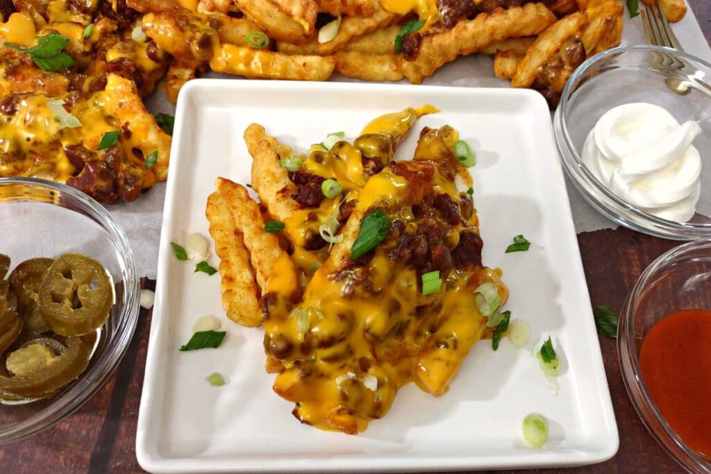 air fryer chili cheese fries with jalapenos, sour cream, and hot sauce on the side