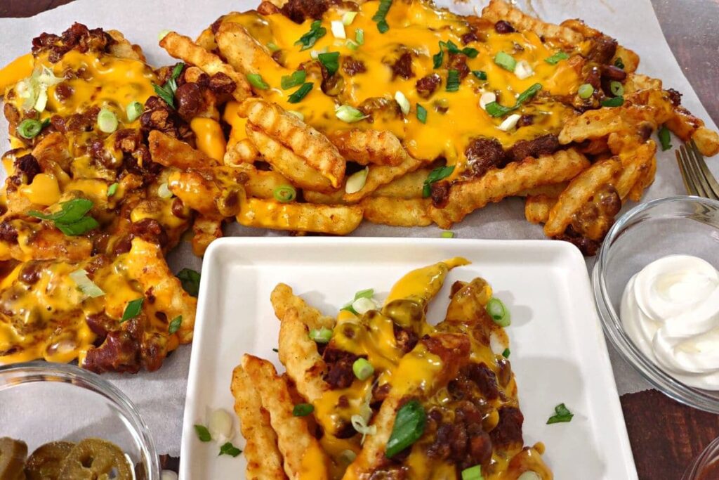 chili cheese fries on a plate with a large batch in the background