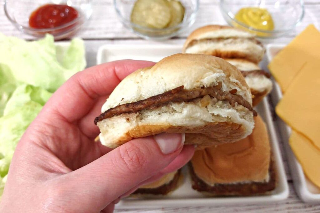 holding a white castle burger slider heated up in the microwave
