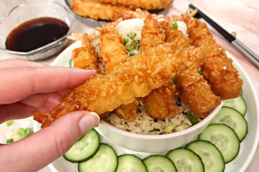 holding an air fried tempura shrimp
