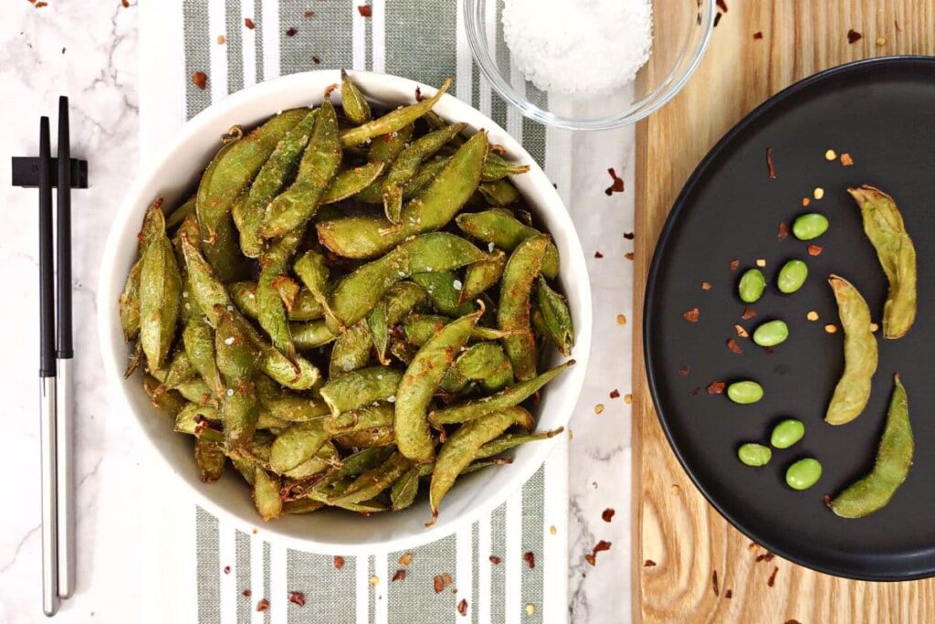 overhead view of air fryer spicy garlic edamame in a white bowl