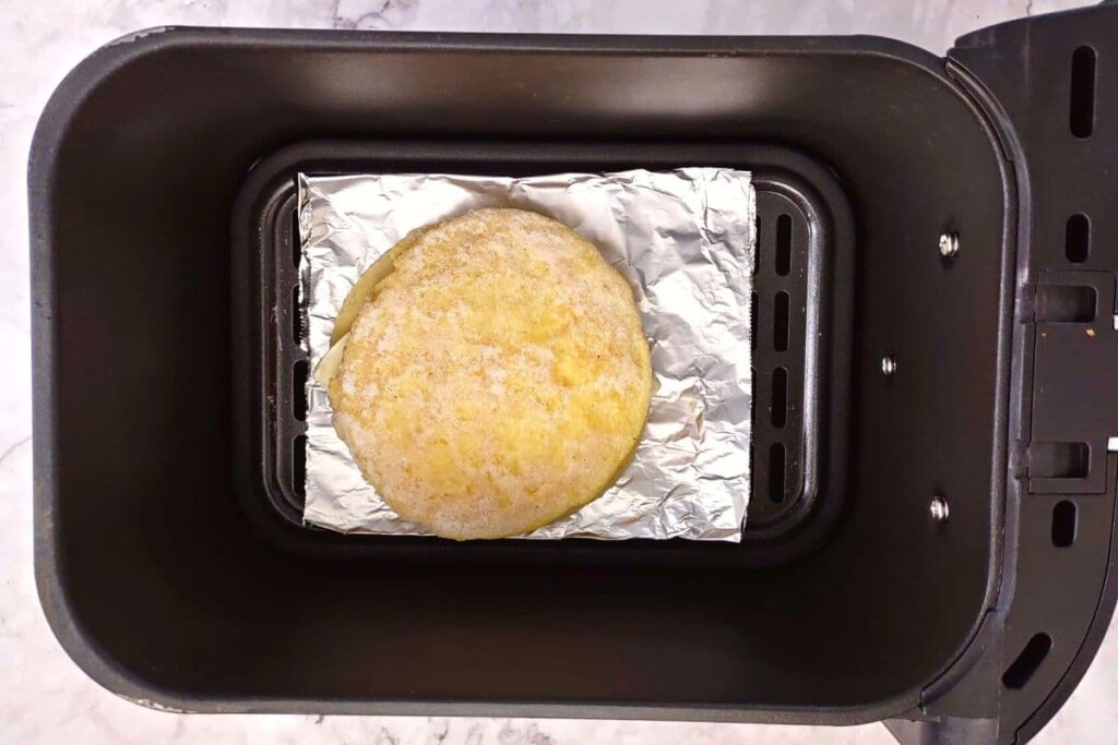 corn and cheese arepa on foil inside air fryer basket