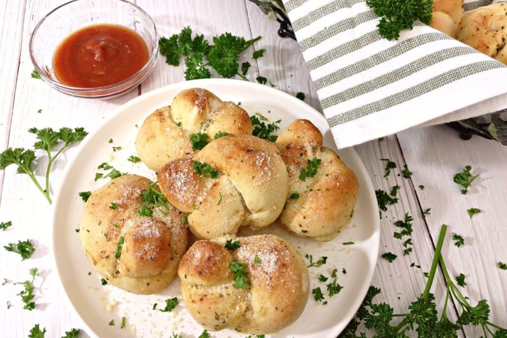 garlic knots heats in the air fryer on a plate with parsley