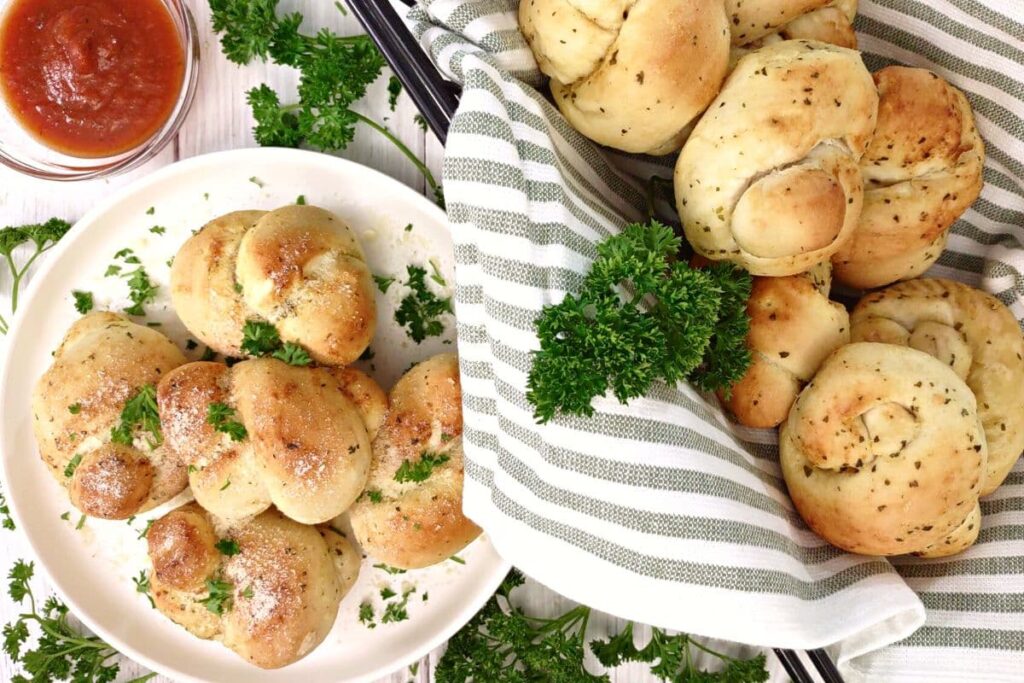 overhead view of air fryer garlic knots on a plate and basket