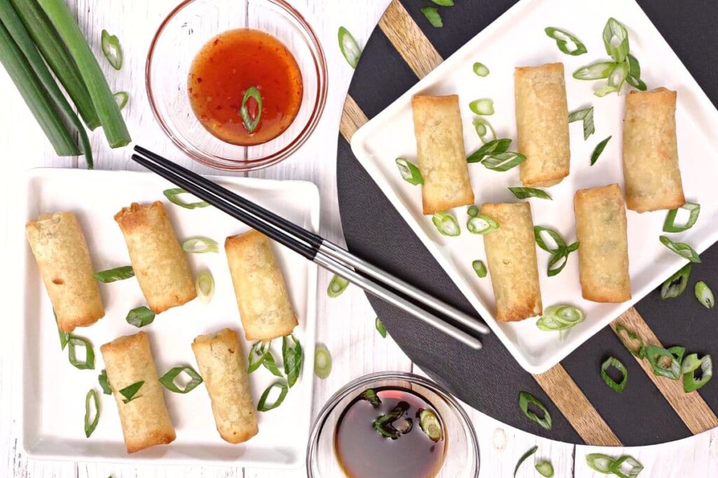 overhead view of reheated air fryer spring rolls on white plates