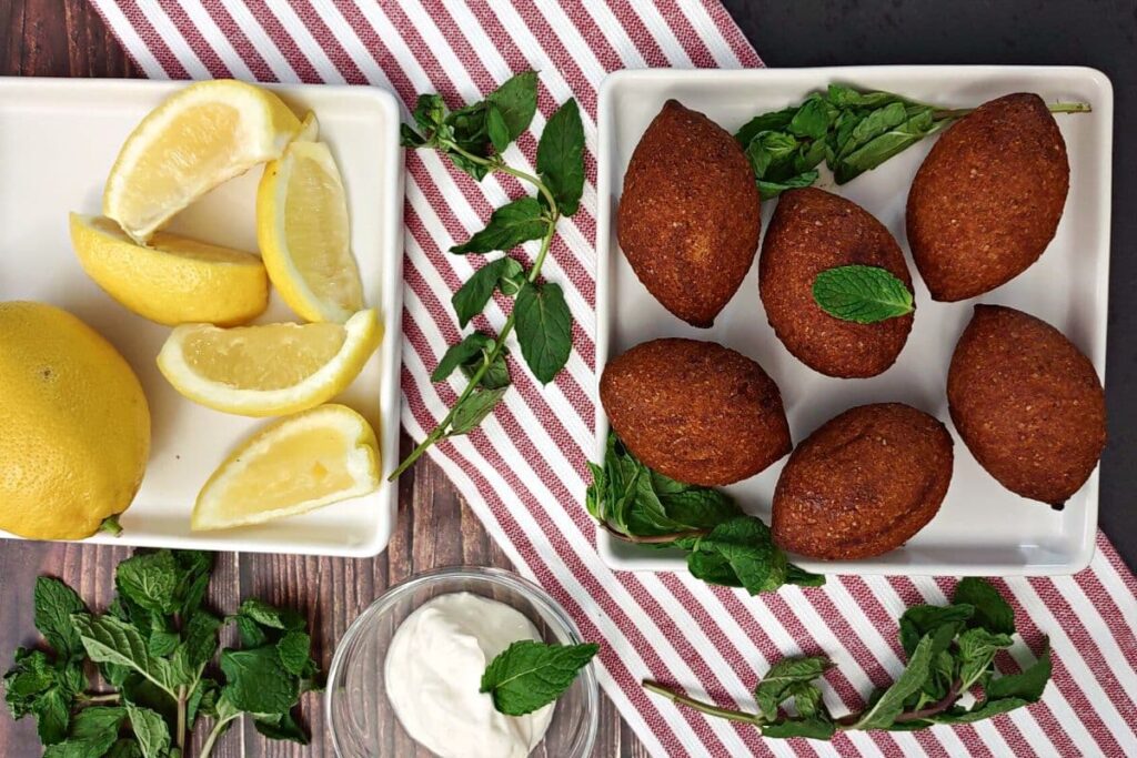 overhead view of trader joes air fried kibbeh next to lemon wedges