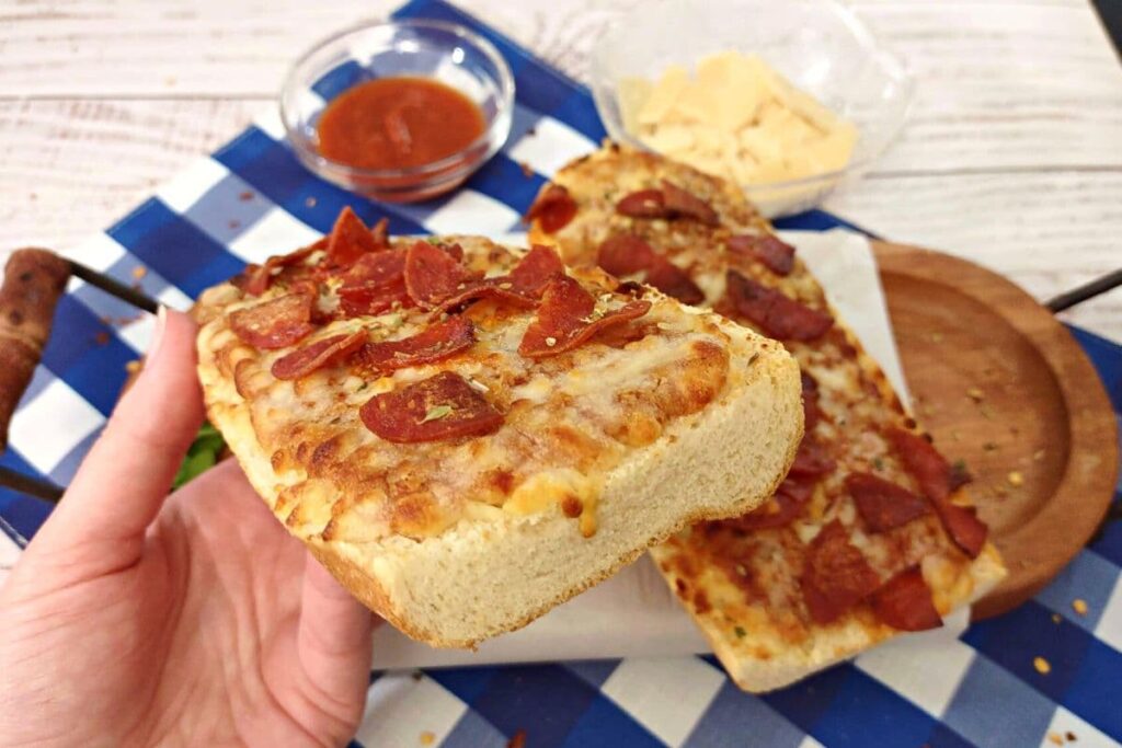 holding red baron french bread pizza made in the air fryer