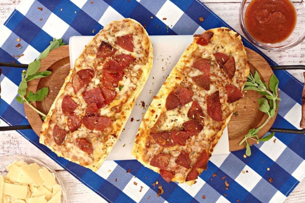 overhead view of 2 red baron french bread pizza on a serving board