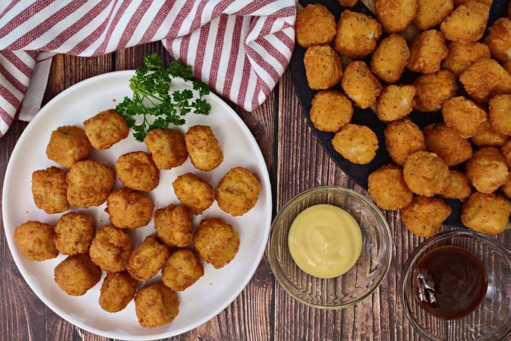 overhead view of crispy air fryer popcorn chicken with dipping sauces