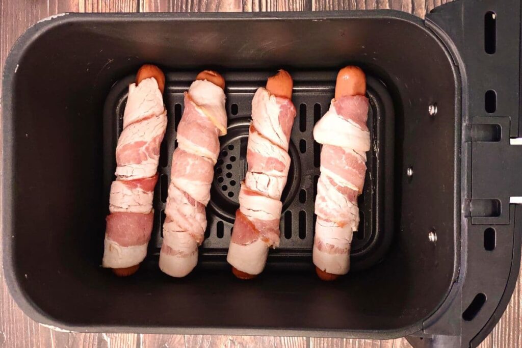 place bacon wrapped hot dogs in air fryer basket