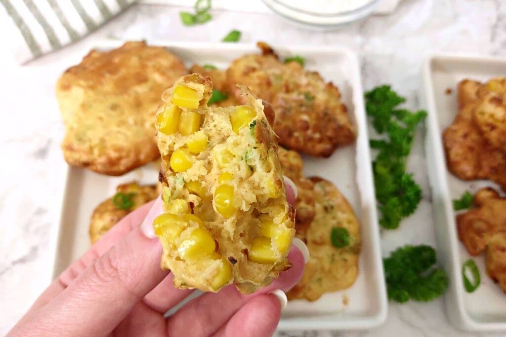 holding up a split in half corn fritter