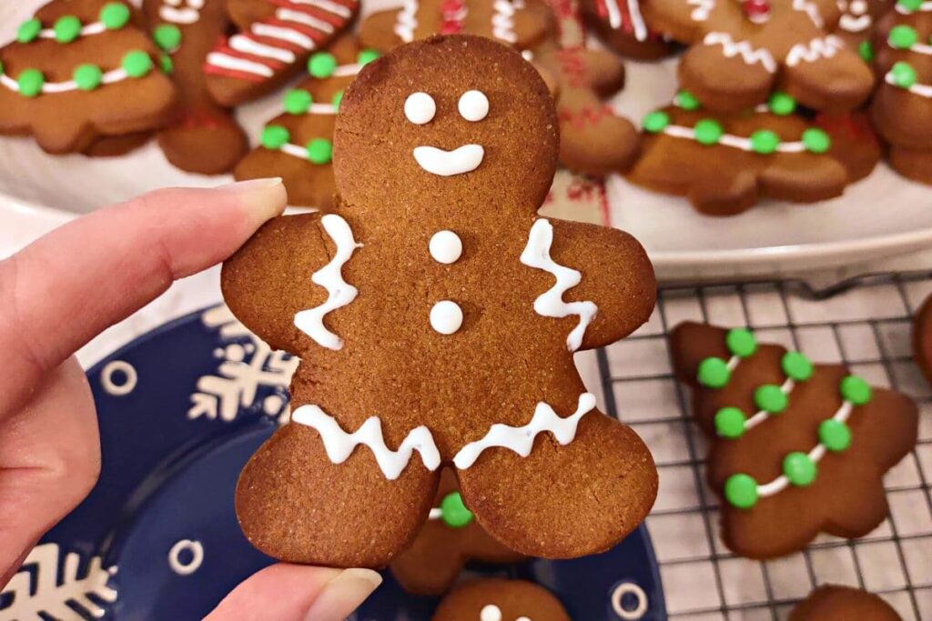holding up an iced air fryer gingerbread man cookie