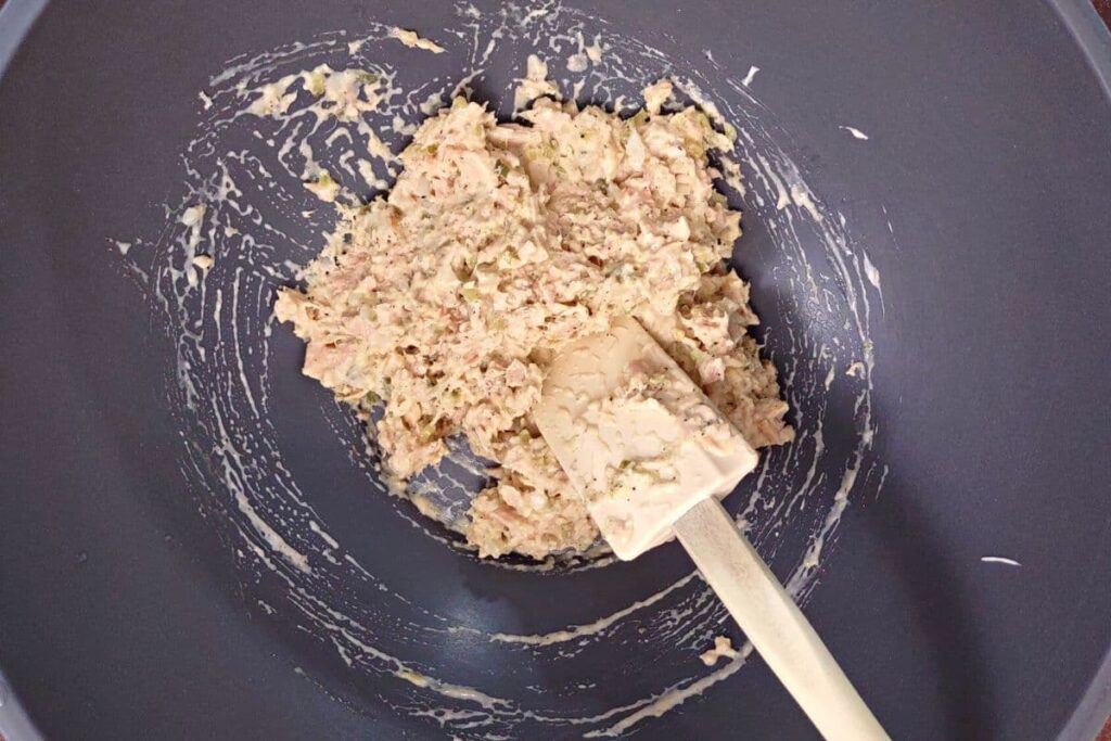 mix ingredients to make tuna salad in a bowl