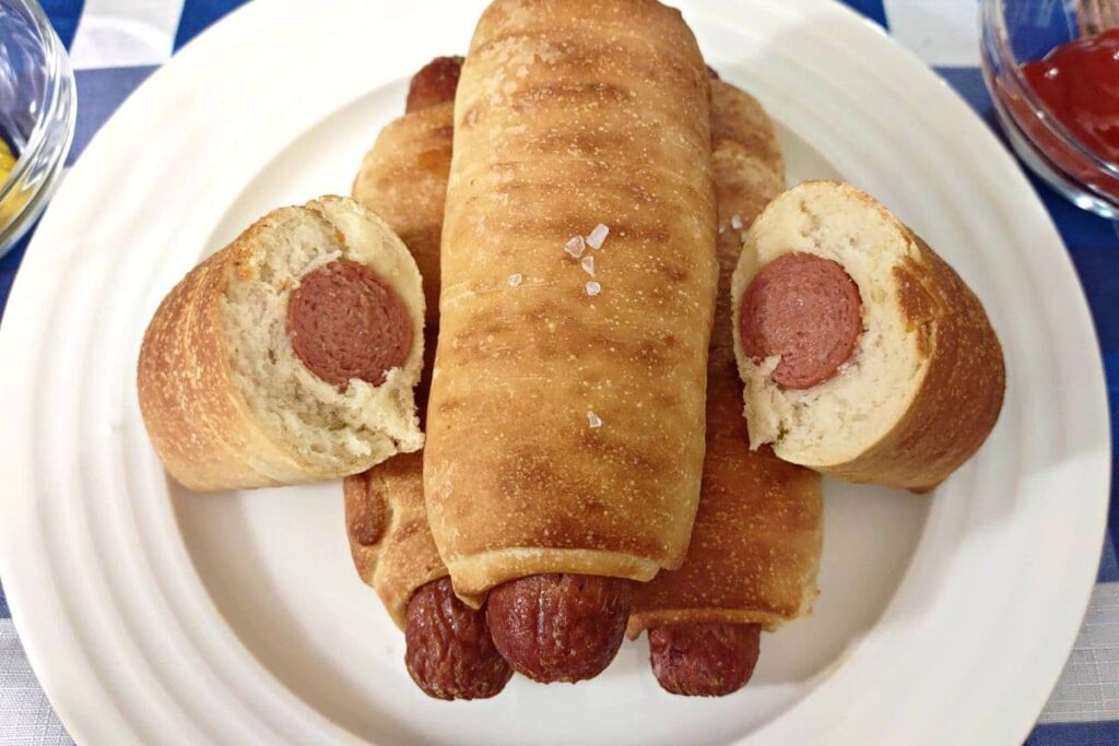 nathan's air fryer pretzel dogs on a plate and cut in half