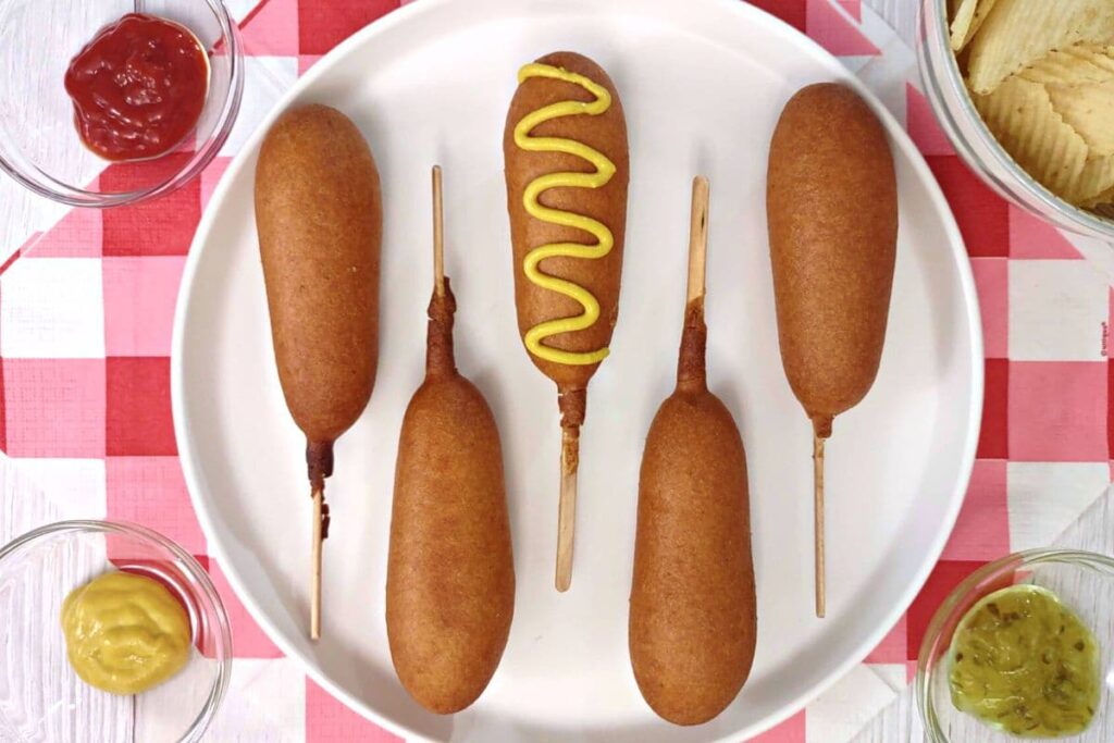 overhead view of 5 corn dogs on a plate