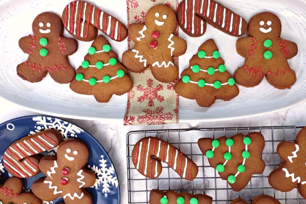 overhead view of air fryer gingerbread cookies shaped like men candy canes and christmas trees on various platters