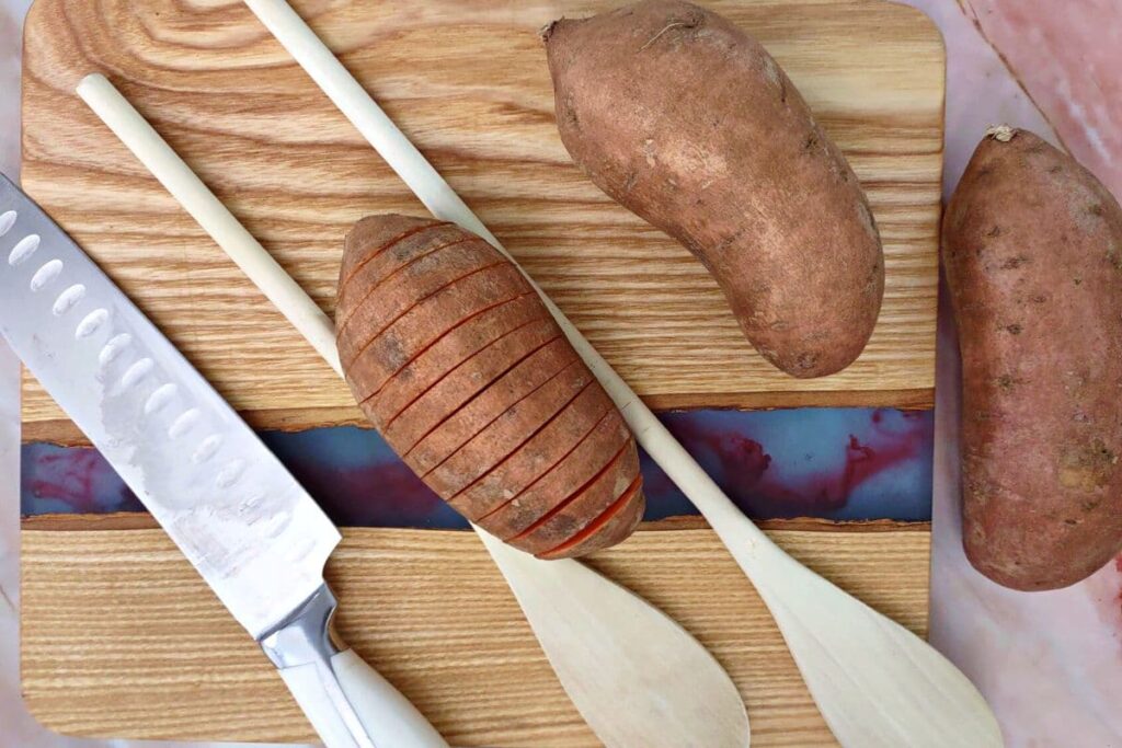 place wooden spoons around sweet potato to hold in place while cutting