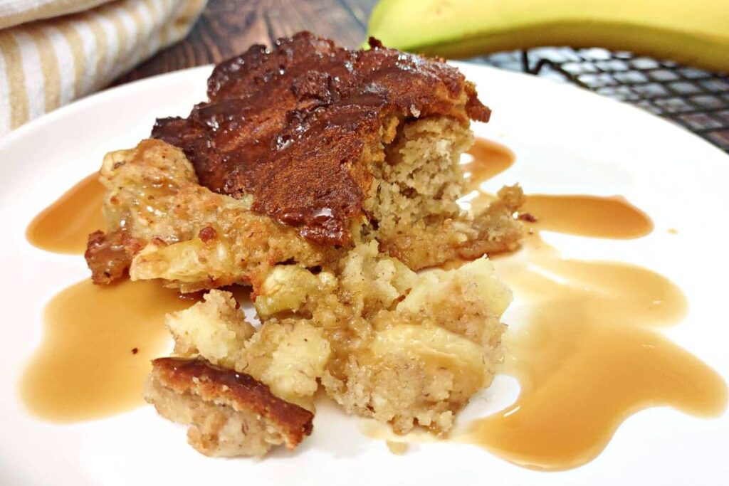 banana bread pudding spilling out on a plate with caramel sauce