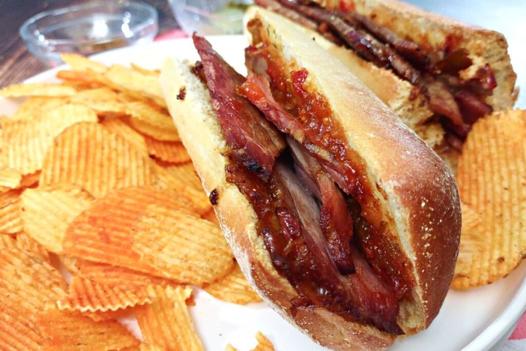 closeup of brisket sandwich with chips
