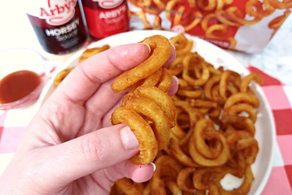 holding up an air fried arbys curly fry