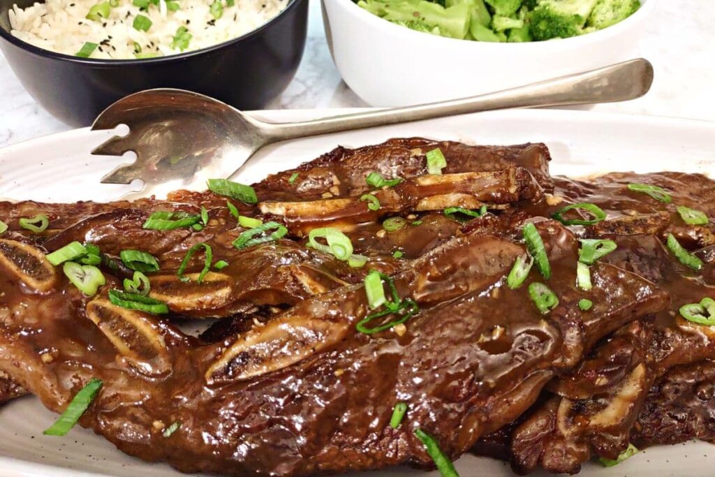 korean beef short ribs on a platter with a serving spoon