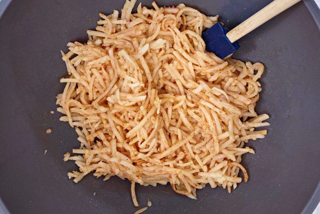 mix hash browns, oil, and seasoning in a bowl