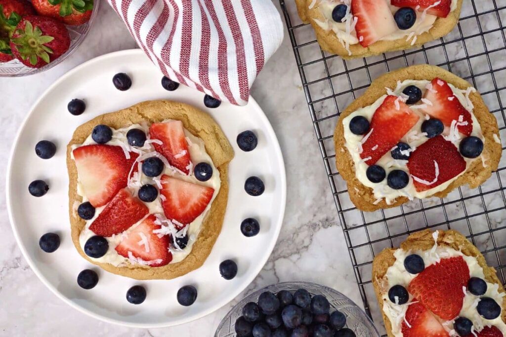 overhead view of air fryer sugar cookie fruit pizza with blueberry and strawberry