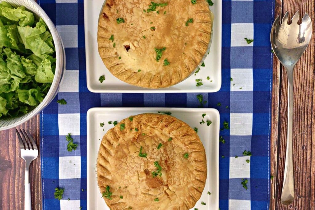 overhead view of two frozen chicken pot pies cooked in the air fryer on a plate