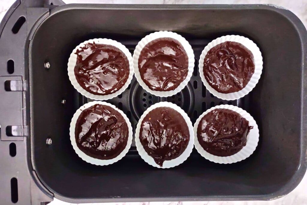 place filled cupcake wrappers in air fryer basket