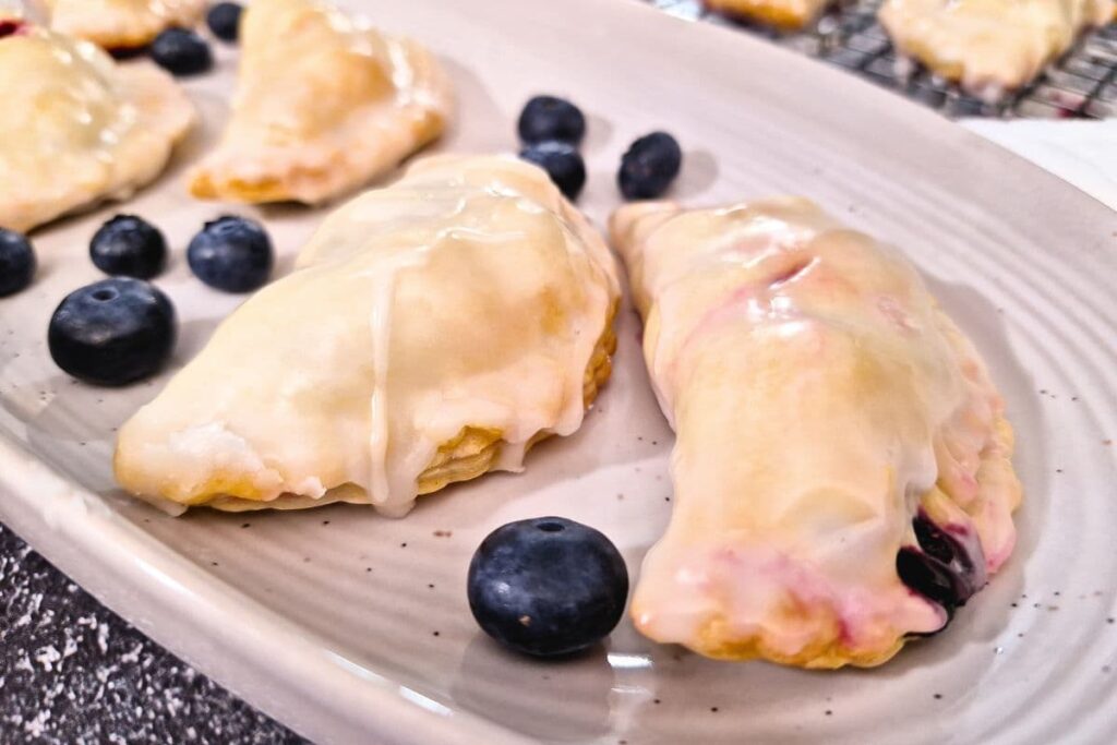 closeup view of crescent shaped blueberry hand pies with a sweet glaze on top