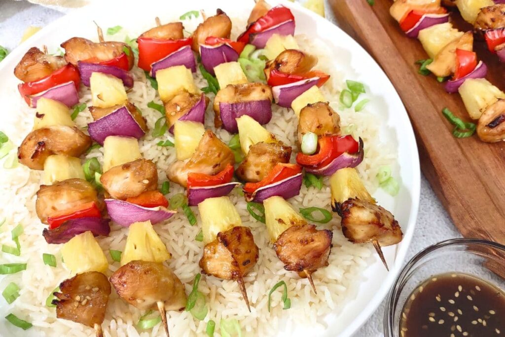 delicious air fryer chicken kabobs on a plate over rice