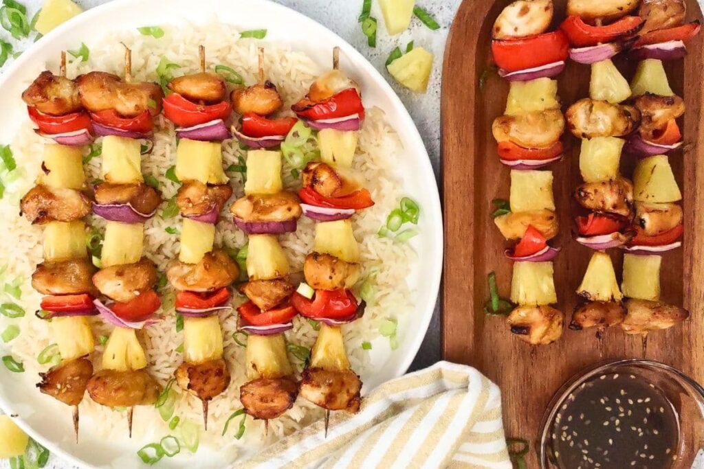 overhead view of teriyaki chicken skewers on a plate with rice